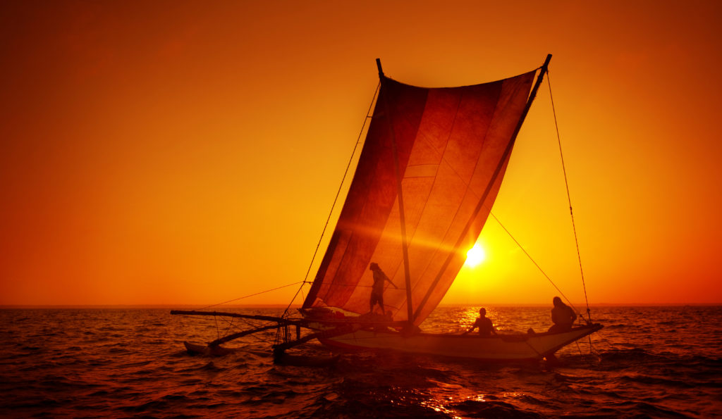Fishermen on a catamaran at Sunset Concept